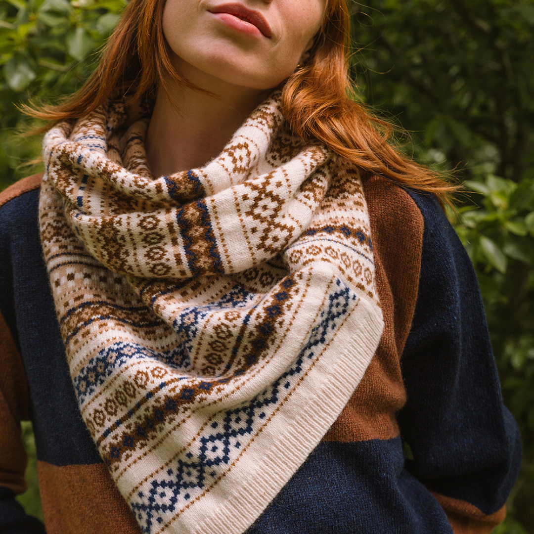 Person wearing a patterned scarf with a blurred green background