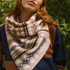 Person wearing a patterned scarf with a blurred green background