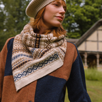Woman wearing a patterned scarf and knit hat outdoors