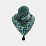 A green patterned knit bandana with a tassel, displayed on a neutral light gray background.