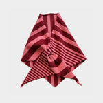 A folded striped knit scarf or bandana in shades of pink and deep red, arranged on a light gray background.