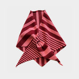 A folded striped knit scarf or bandana in shades of pink and deep red, arranged on a light gray background.
