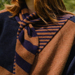 Close-up of a person wearing a striped scarf with a blurred natural background