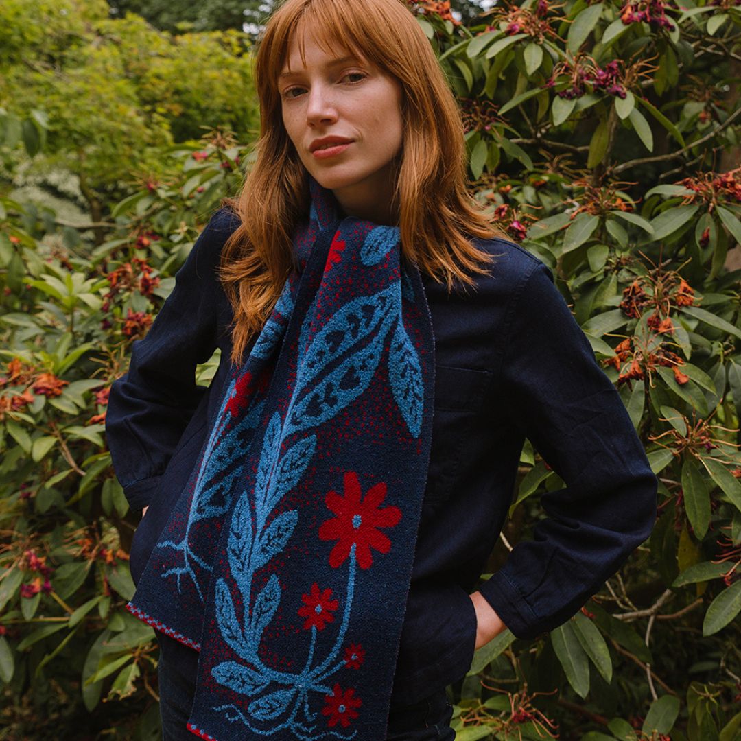 Woman wearing a blue and red patterned scarf in a garden setting