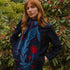Woman wearing a blue and red patterned scarf in a garden setting