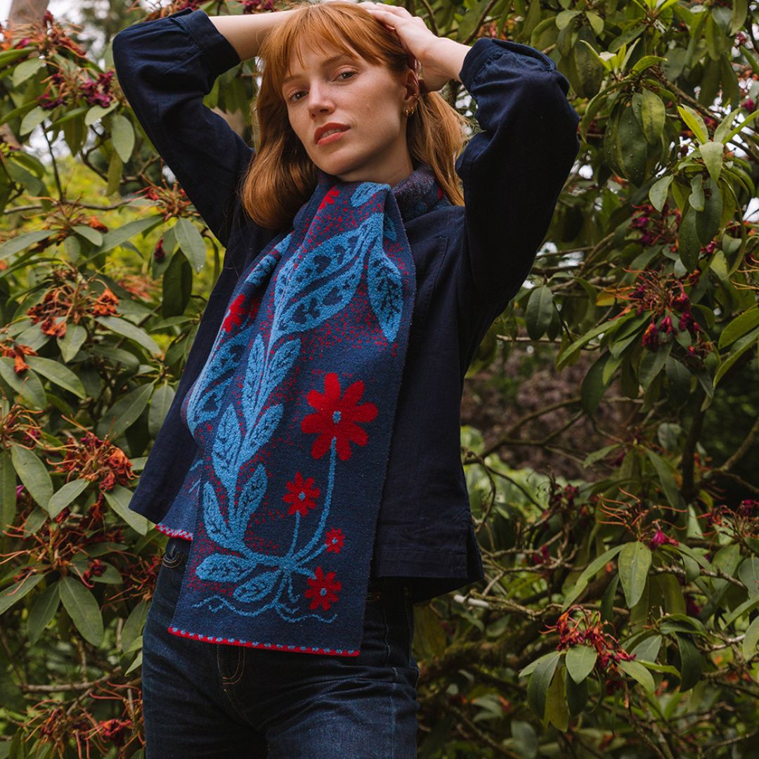 Woman wearing a blue and red patterned scarf in a forest setting