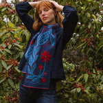 Woman wearing a blue and red patterned scarf in a forest setting