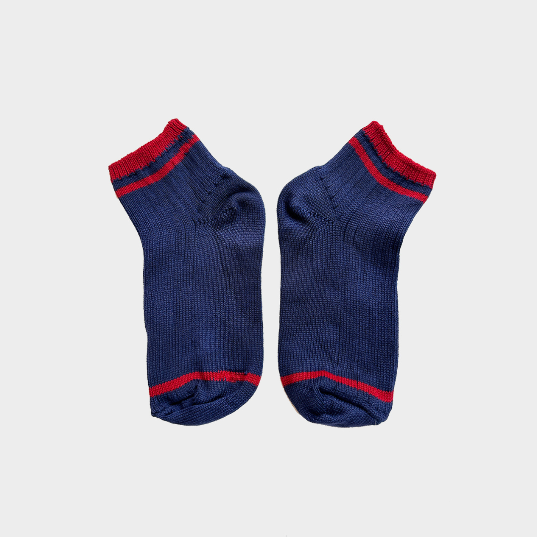 A pair of navy blue knit ankle socks with red stripes at the cuff, toe, and heel, displayed flat against a light gray background.