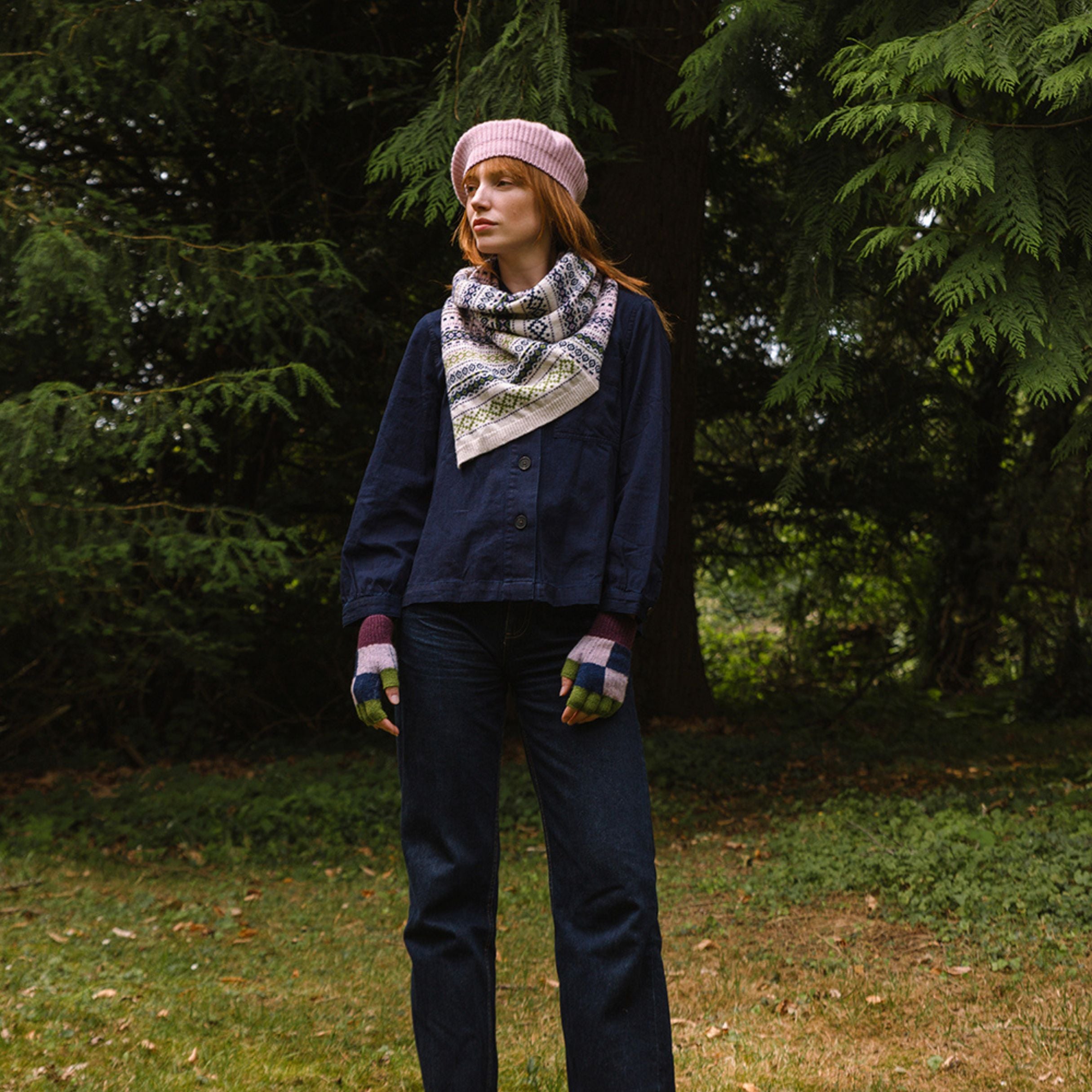 woollen twisted snood in light pinks, greens and blues worn by model in the woods.