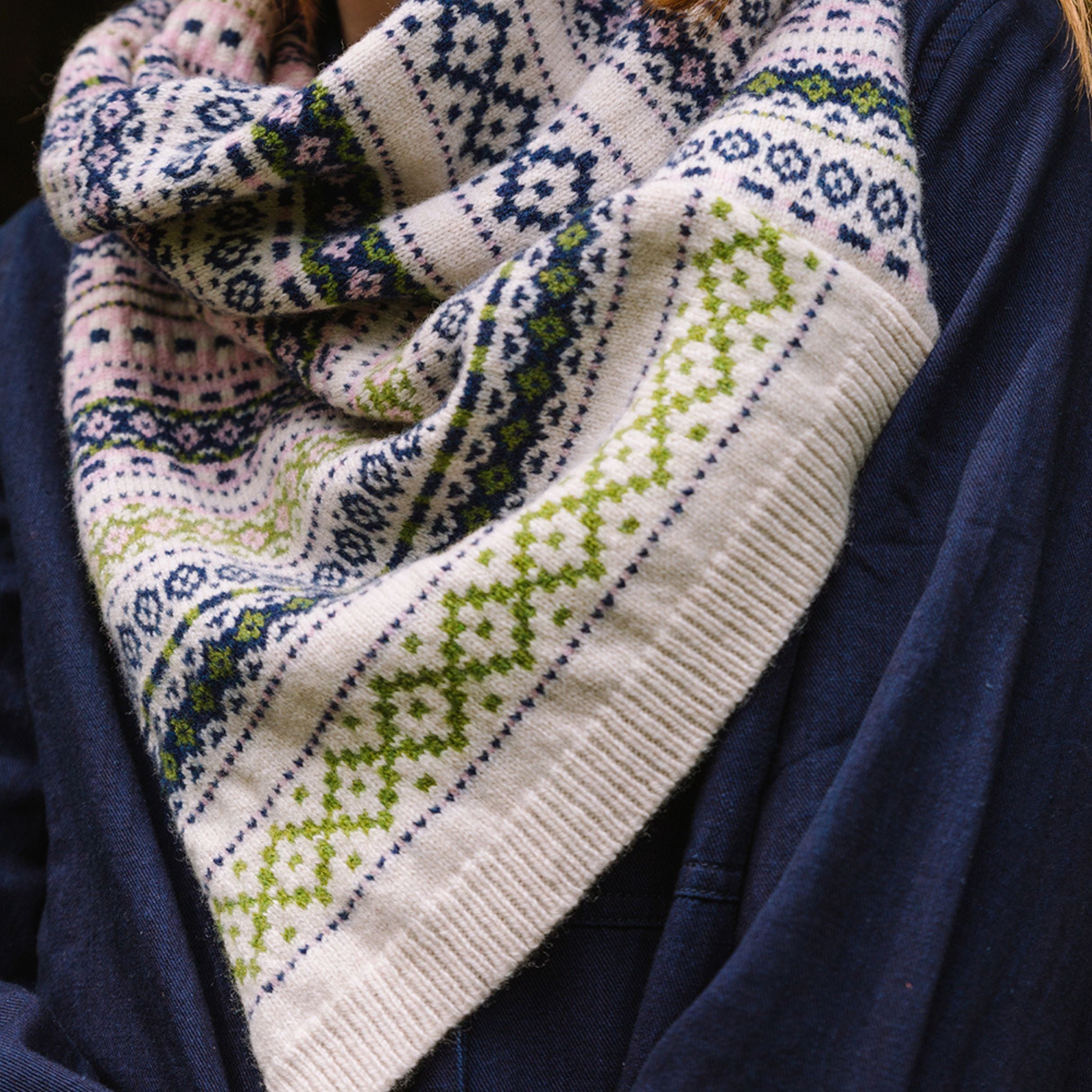 woollen twisted snood in light pinks, greens and blues worn by model in the woods.