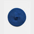 A blue knit beret with a textured radial pattern and a small matching knit pom-pom on top, photographed flat against a light gray background.