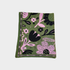 A blanket with a green base featuring a blue and pink floral pattern, finished with a striped border, shown flat on a light gray background.