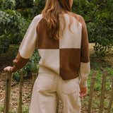 model in the woods wearing check cardigan in cream and brown.