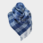 A blue and white plaid scarf with fringed edges, styled in a loop against a light gray background.