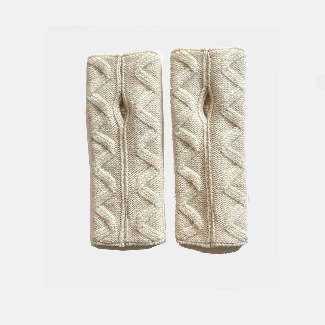A pair of cream-colored cable-knit wrist warmers with a textured chevron pattern, displayed side-by-side on a light gray background.