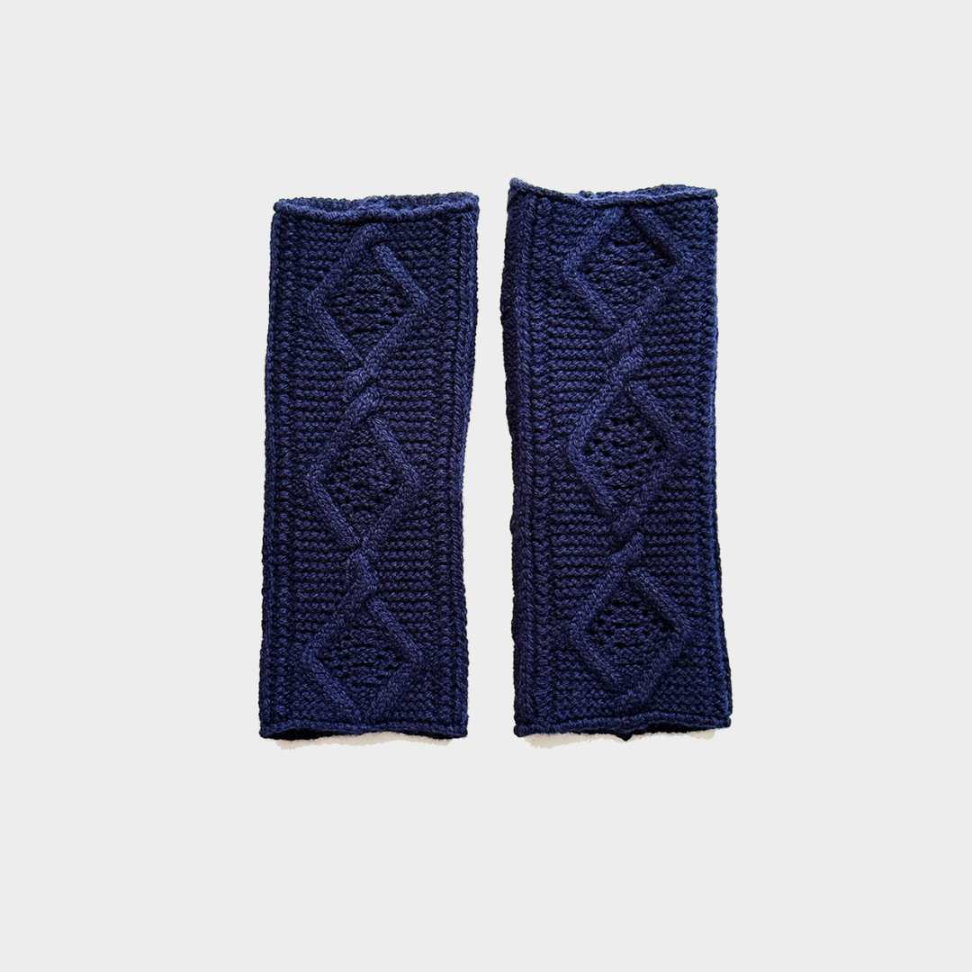 A pair of navy blue cable-knit wrist warmers with diamond patterns, displayed flat against a light gray background.r