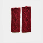 A pair of dark red knitted arm warmers with a textured diamond pattern, displayed flat against a light gray background.