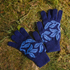 Pair of blue gloves with leaf pattern on grass