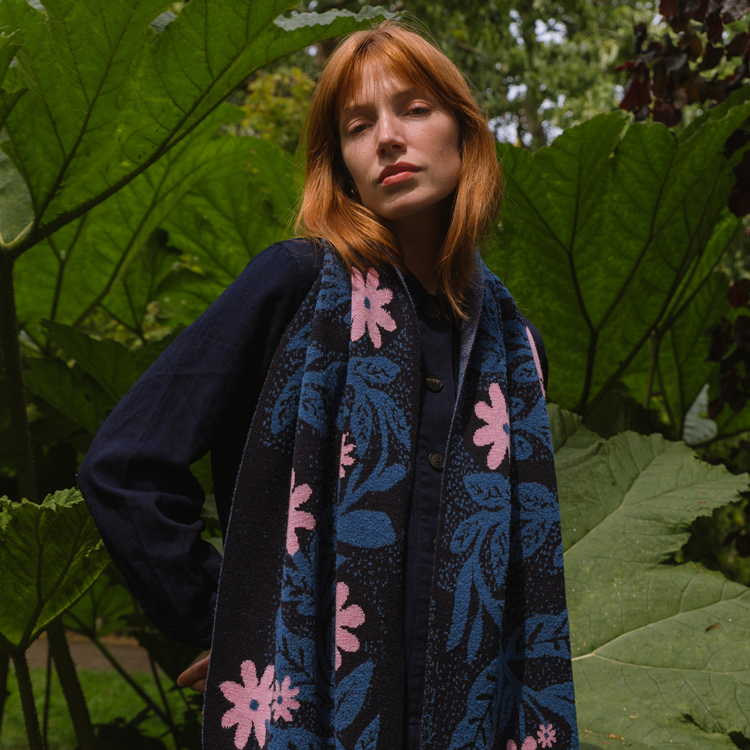 Woman wearing a floral scarf in a garden setting