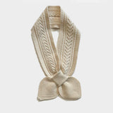 A cream-colored cable-knit scarf with a knotted bow at the bottom, displayed against a light gray background.