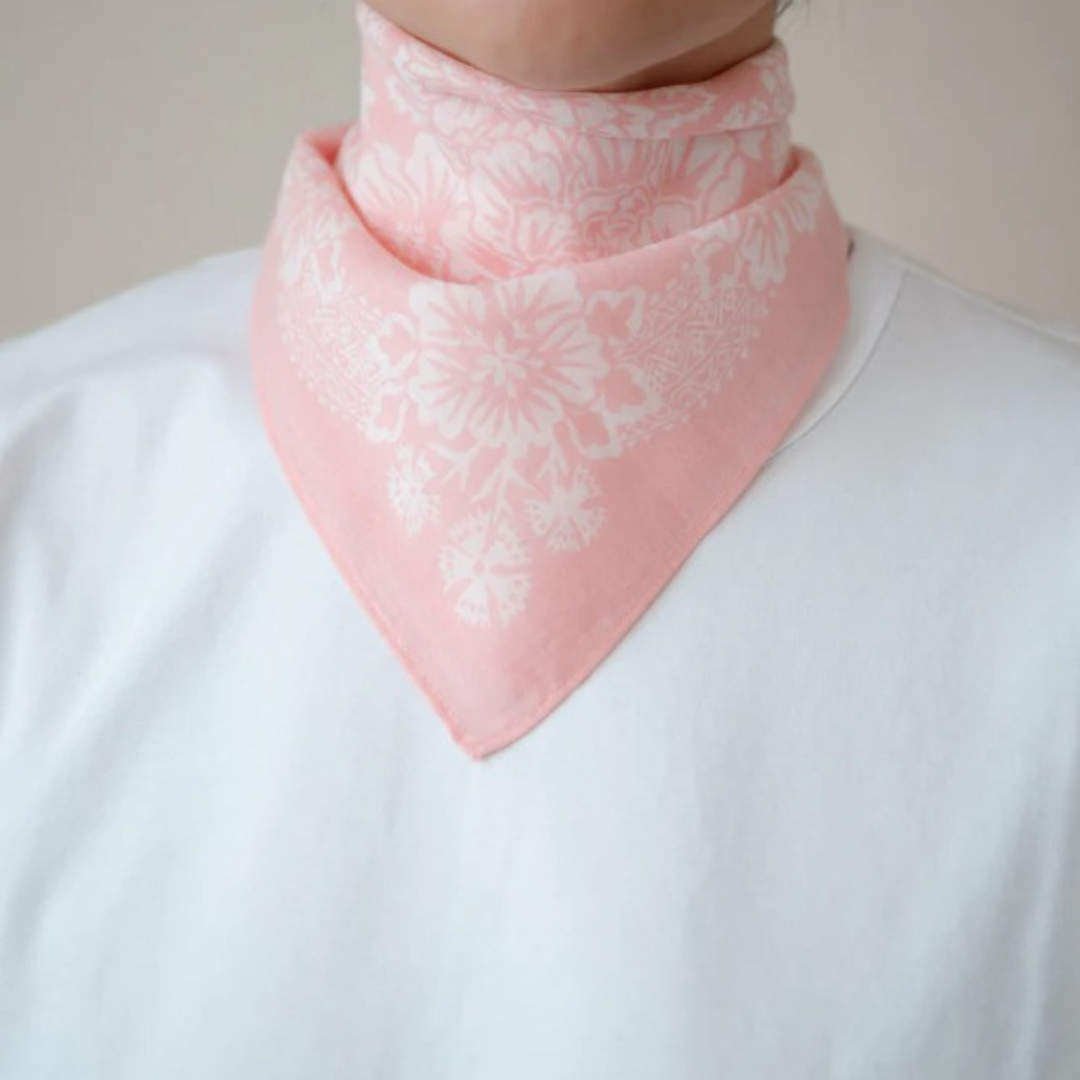 Person wearing a pink floral bandana over a white shirt