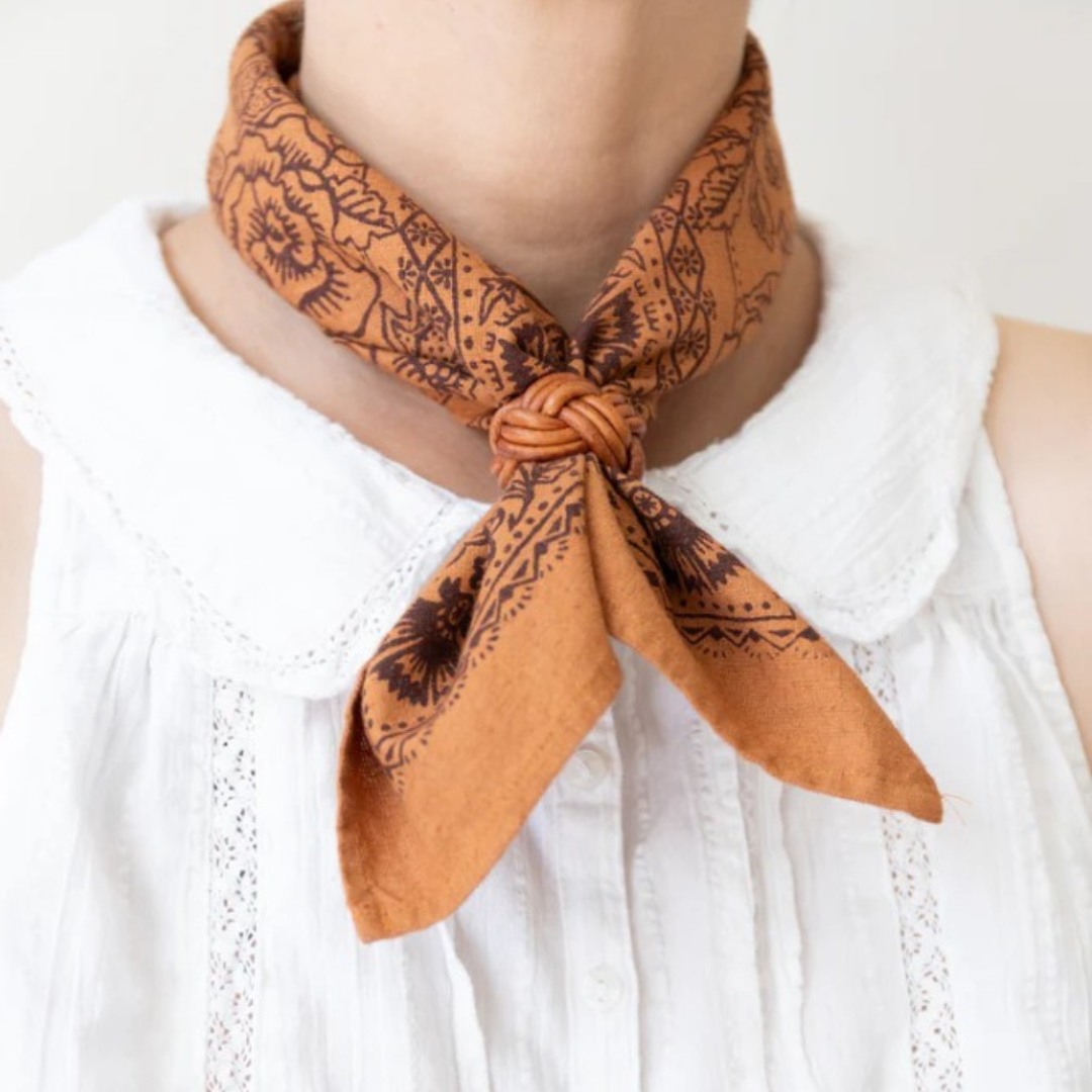 Person wearing a brown patterned scarf on a white background