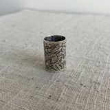 Silver embossed slider on a textured fabric surface