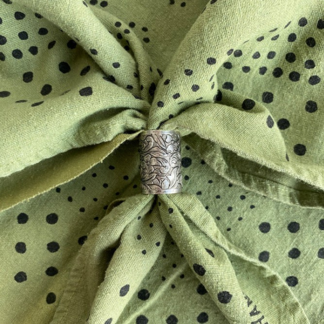 Silver slider on a green fabric with black polka dots