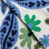 A close-up socks with a blue, green, and navy floral and paisley pattern on a white background.
