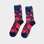 A pair of navy blue crew socks with a vibrant pink and red floral pattern, displayed flat against a light gray background.