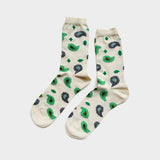 A pair of cream-colored crew socks with a green and dark blue paisley pattern, displayed against a light gray background.