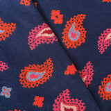 A close-up socks with a repeating paisley pattern in bright orange, pink, light blue, and cream.