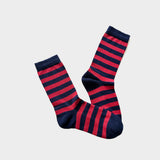 A pair of crew socks with alternating horizontal stripes of dark navy blue and bright red, displayed against a light gray background.