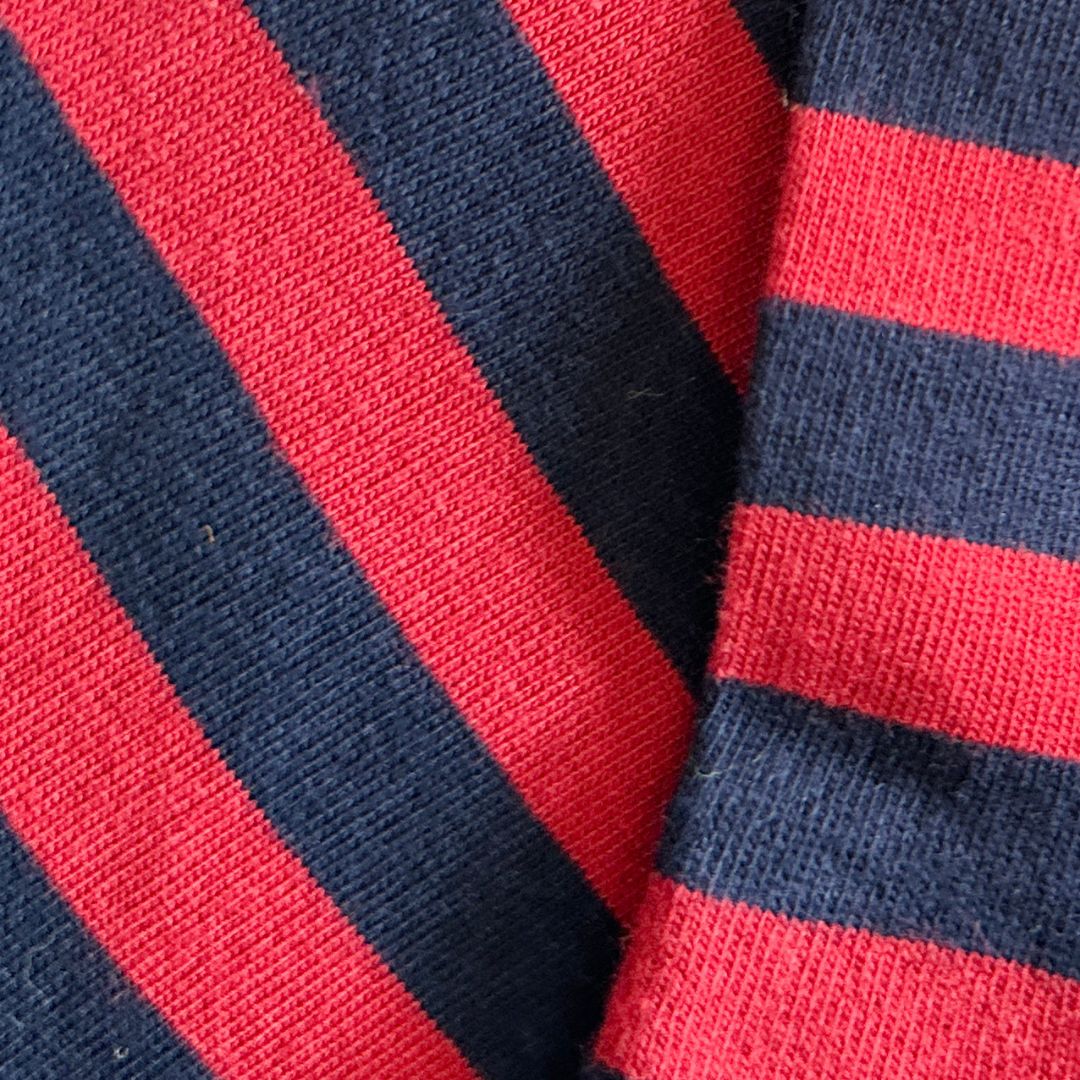 Close-up of socks with alternating red and navy blue diagonal stripes.
