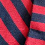 Close-up of socks with alternating red and navy blue diagonal stripes.