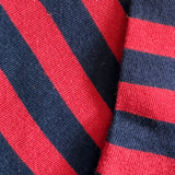 Close-up of socks with alternating red and navy blue diagonal stripes.