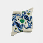 socks with a cream-colored base featuring a blue and green floral and leaf pattern, photographed on a light gray background.