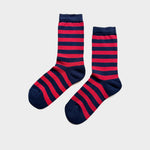 A pair of crew socks with horizontal navy blue and red stripes, displayed on a light gray background.