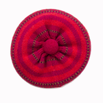 Red knitted beret with a flower design on a white background