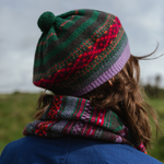 Person wearing a colorful knitted hat and scarf in a natural setting