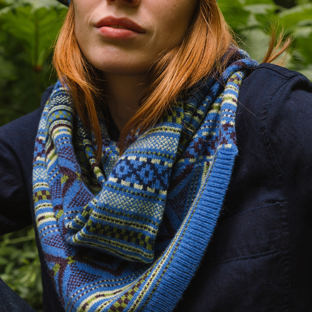 Person wearing a blue patterned scarf with a natural background