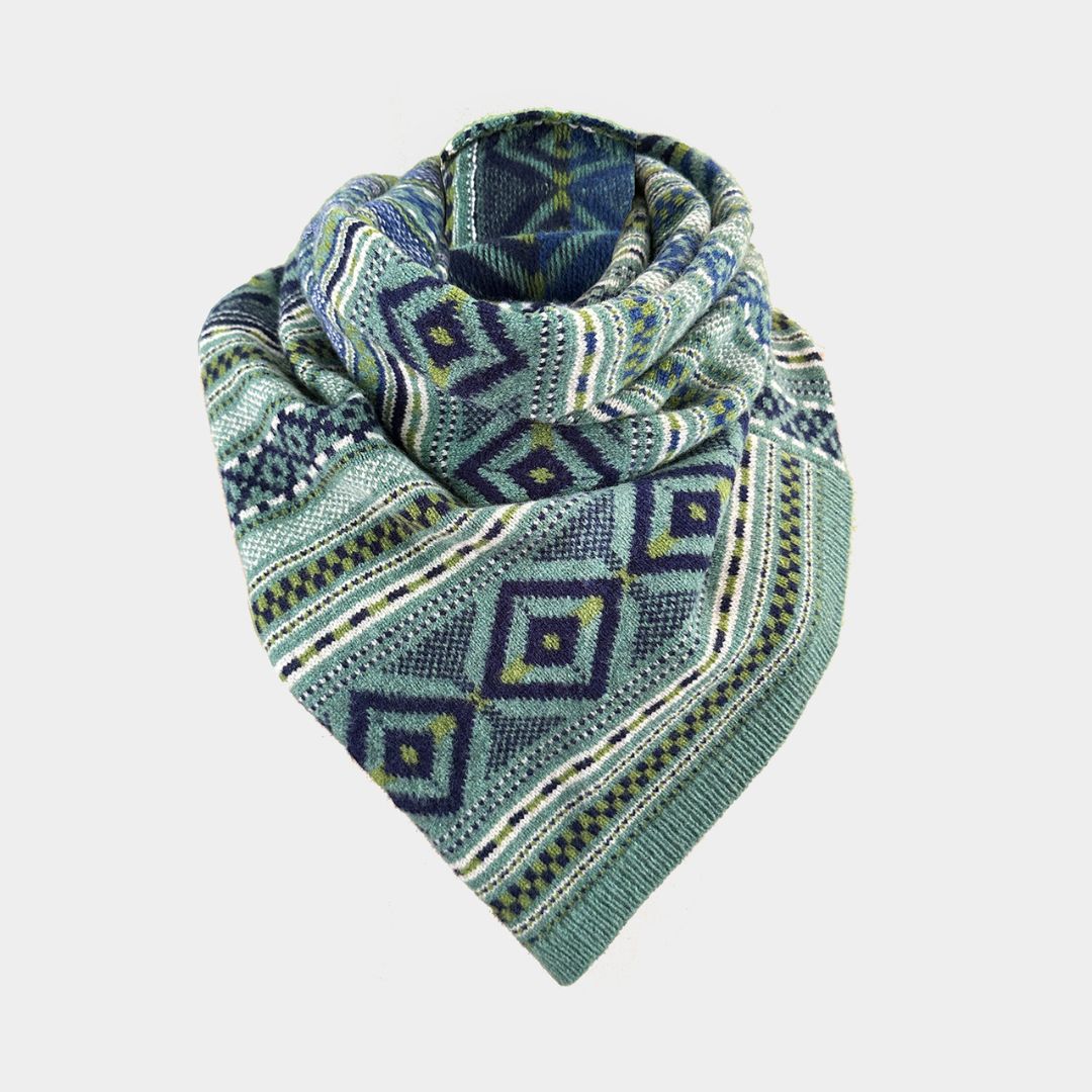 A knitted triangular scarf with a geometric diamond pattern in shades of teal, blue, and olive green, displayed on a light gray background.