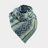 A knitted triangular scarf with a geometric diamond pattern in shades of teal, blue, and olive green, displayed on a light gray background.