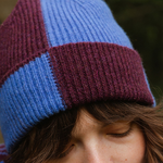Close-up of a person wearing a blue and purple striped knit hat.