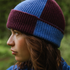 Person wearing a blue and purple knit beanie in a natural setting