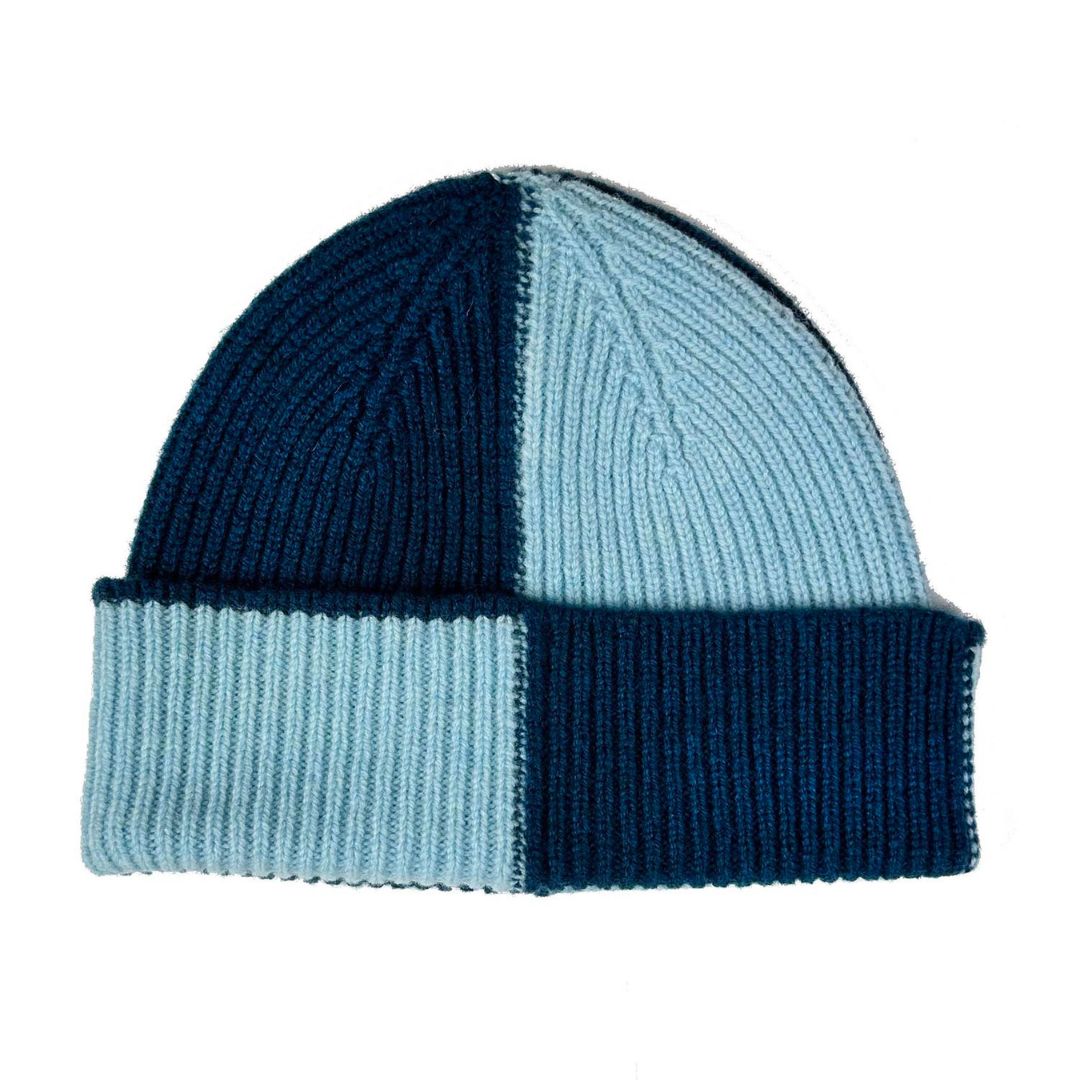 A ribbed knit beanie hat with a four-color block pattern in navy blue, light blue, and dark navy, shown on a plain white background.