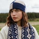 Person wearing a blue and white patterned scarf and hat outdoors